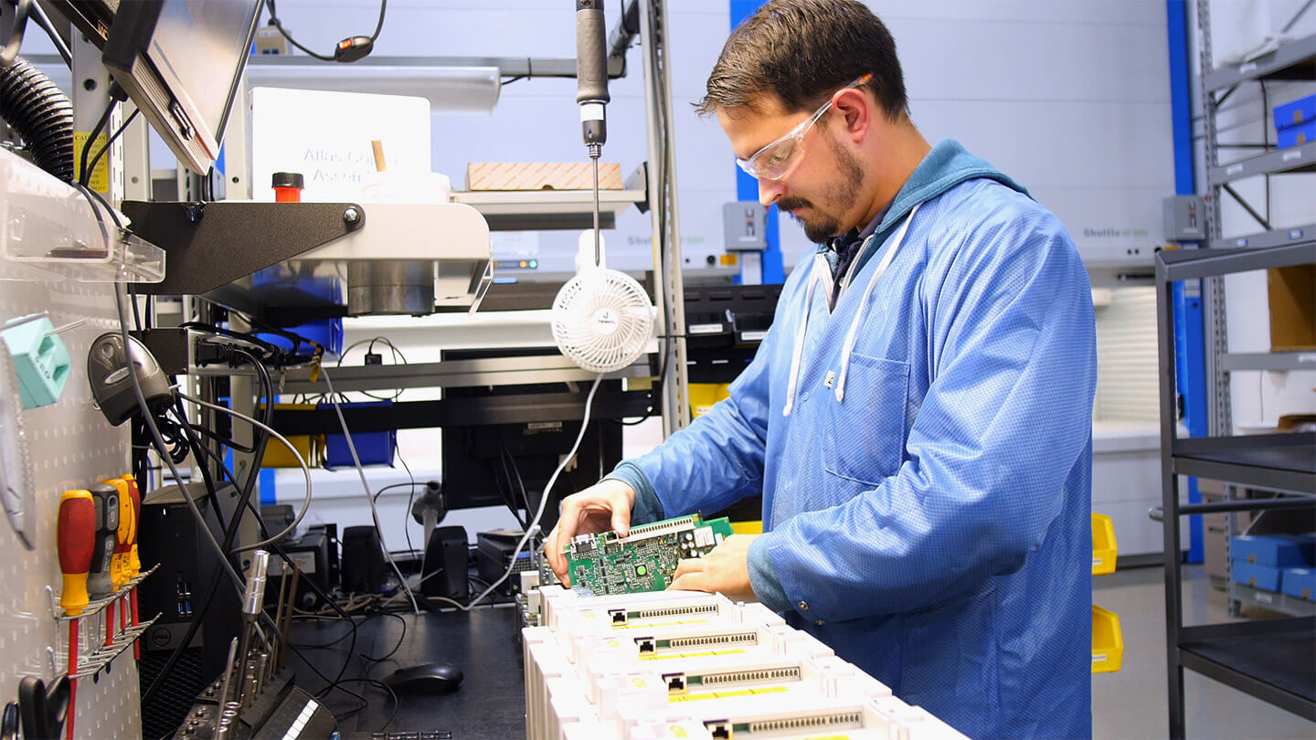 KEB America drive assembly line with a manufacturing tech installing a circuit board into a VFD.
