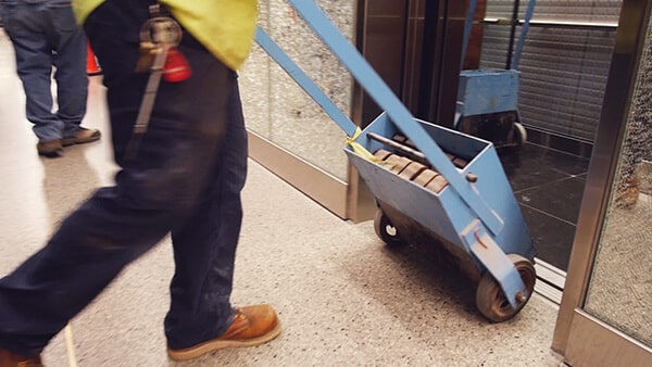 Elevator technician is adding Weight to Balance an elevator Car during construction
