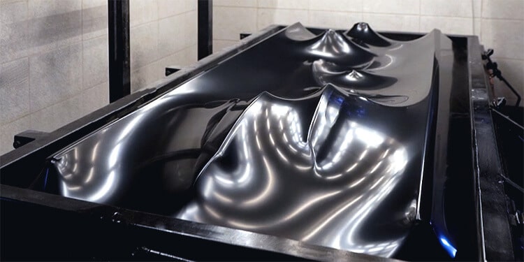 A vacuum-style thermo forming machine for plastic vehicle panels